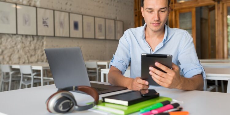 Jovem estudando em tablet, usando aplicativos para aprender matemática de forma gratuita.