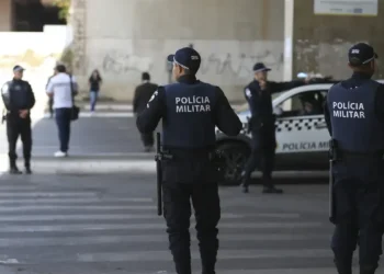 Policiais militares patrulhando uma área urbana durante uma operação de segurança.