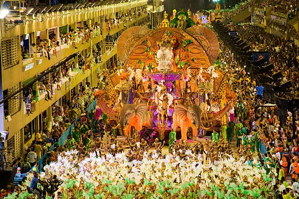 Desfile de escola de samba no Sambódromo com carro alegórico e foliões fantasiados