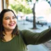 Mulher sorrindo e tirando uma selfie, representando o alerta sobre o golpe da selfie