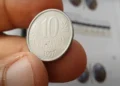 Moeda de 10 centavos de 1997 segurada entre os dedos