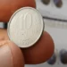 Moeda de 10 centavos de 1997 segurada entre os dedos