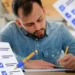 Candidato concentrado se preparando para a prova do concurso da Polícia Penal RJ.