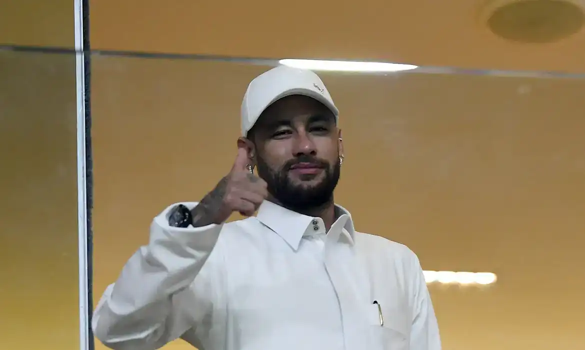 Neymar Jr. sorrindo e fazendo sinal de positivo durante evento.