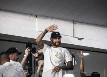 Neymar Jr. acenando para os fãs durante evento no estádio.