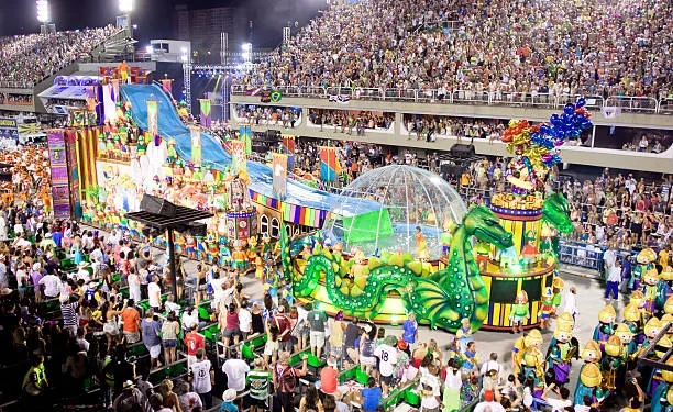 Desfile de Carnaval no Sambódromo com carros alegóricos e foliões em um espetáculo vibrante de cores e tradições