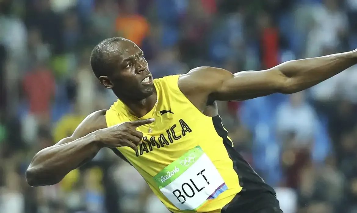 Atleta jamaicano comemorando com pose icônica após vitória na Olimpíada.