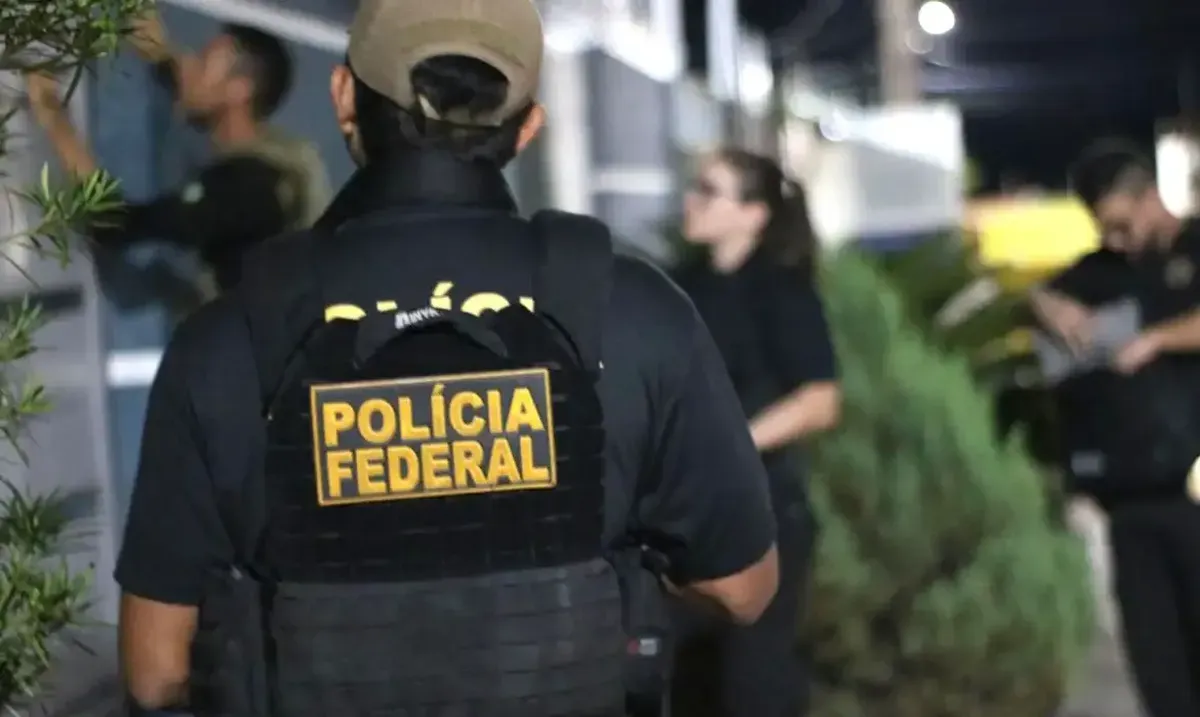 Agentes da Polícia Federal realizando uma operação noturna.