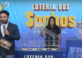 Apresentador anuncia os números da Loteria dos Sonhos de sexta-feira (14/03), com assistentes ao fundo realizando o sorteio