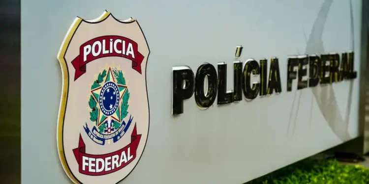 Placa da Polícia Federal do Brasil em destaque em uma estrutura metálica com fundo desfocado.