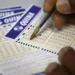 Pessoa marcando números em um bilhete da loteria Quina