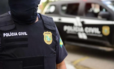 Preparação para o Concurso da Polícia Civil do Ceará Policial civil mascarado com colete tático ao lado de viatura no Ceará