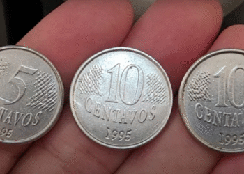 Moedas antigas de 5 e 10 centavos do ano de 1995 exibidas na mão