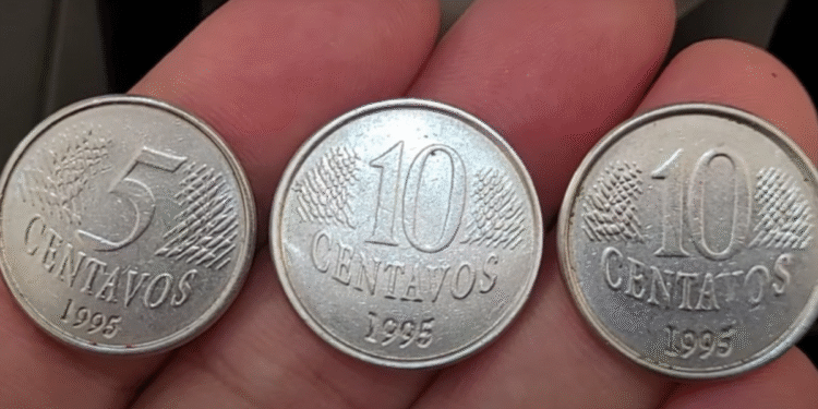 Moedas antigas de 5 e 10 centavos do ano de 1995 exibidas na mão