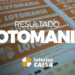 Resultado Lotomania concurso 2754 com volante laranja da loteria e logo das Loterias CAIXA em fundo desfocado