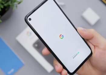 Pessoa segurando celular Android novo com logo do Google na tela durante processo de inicialização
