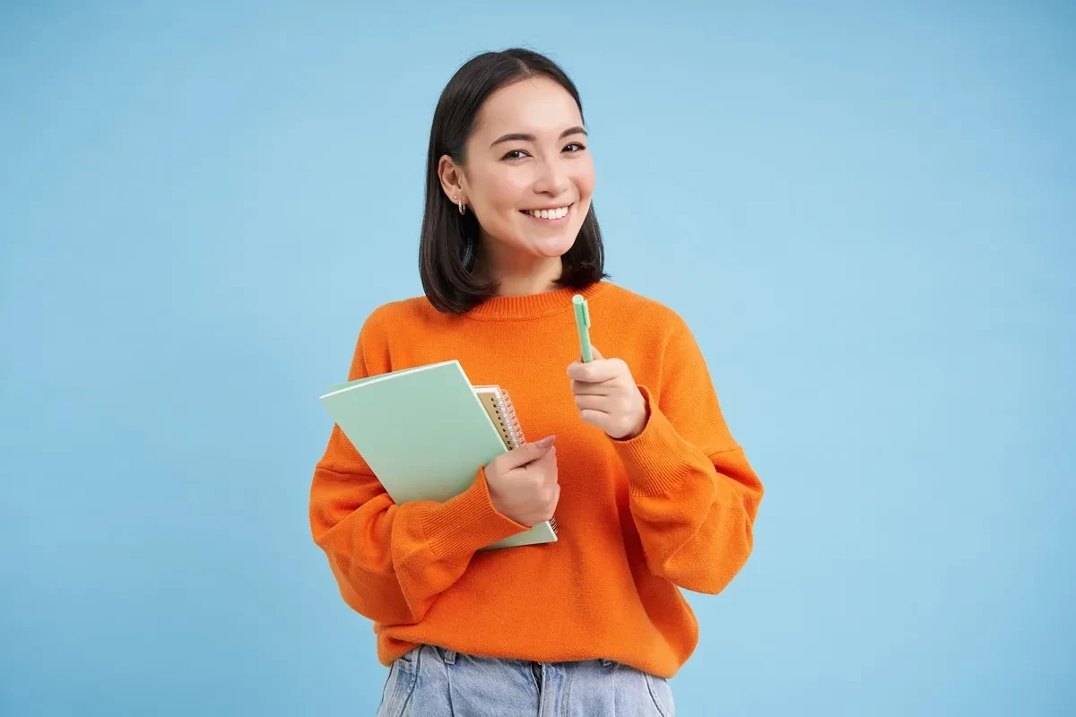 concurso da Prefeitura Mulher sorrindo com materiais de estudo