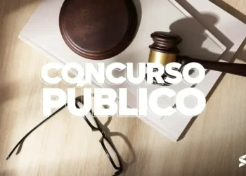 Martelo da justiça ao lado de óculos e documentos com texto "Concurso Público".