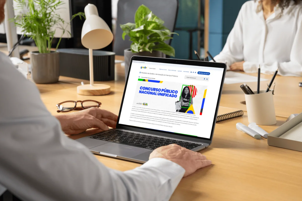 Acesso ao site do CNU 2025 Homem acessando no notebook o site do governo com informações sobre o Concurso Público Nacional Unificado.