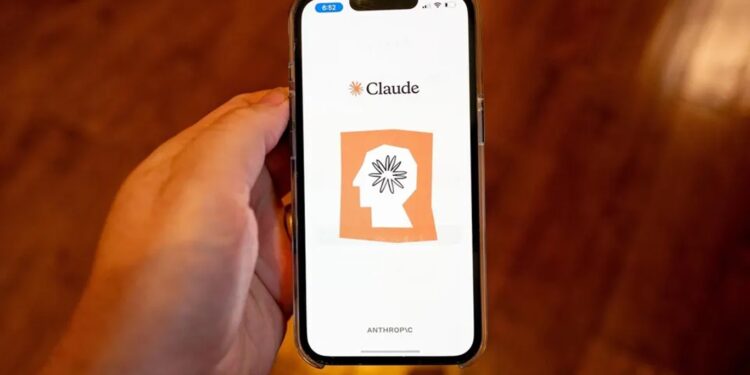 Pessoa segurando um celular com o aplicativo Claude AI da Anthropic aberto na tela