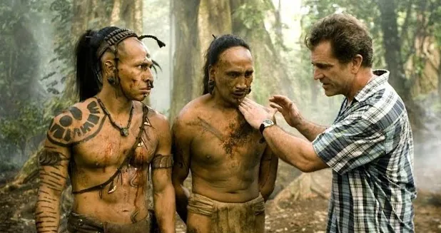 Cena de Apocalypto, direção de Mel Gibson Cena do filme Apocalypto, com Mel Gibson dirigindo atores indígenas