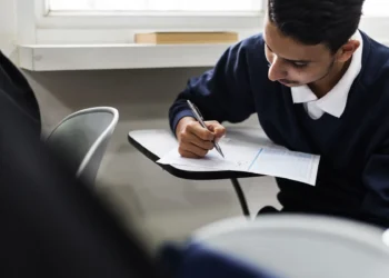 Estudante concentrado preenchendo folha de respostas durante exame