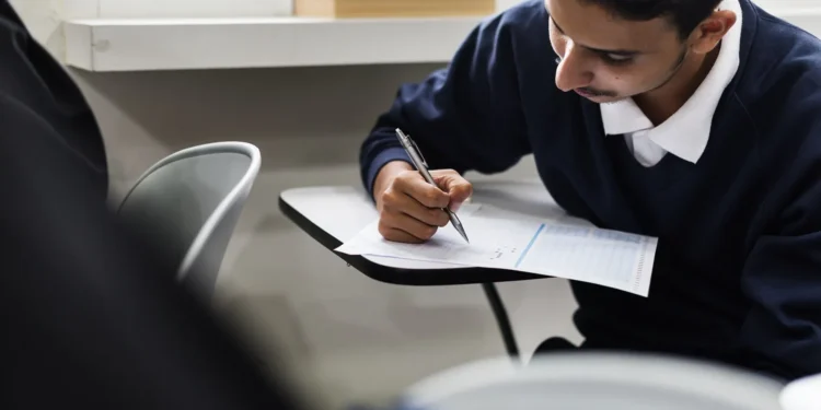 Estudante concentrado preenchendo folha de respostas durante exame