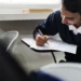 Estudante concentrado preenchendo folha de respostas durante exame