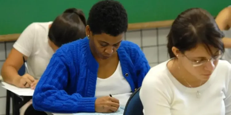 Candidatos concentrados preenchendo prova em sala de aula
