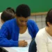 Candidatos concentrados preenchendo prova em sala de aula