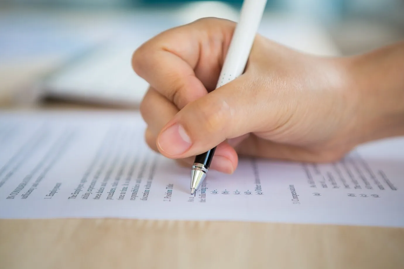 concurso da Prefeitura Pessoa preenchendo formulário de inscrição para concurso, com caneta preta e atenção ao processo.