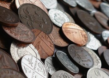 moedas diversas espalhadas, representando colecionismo e possíveis raridades