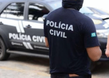 Agente da Polícia Civil em frente a viatura durante operação no Ceará