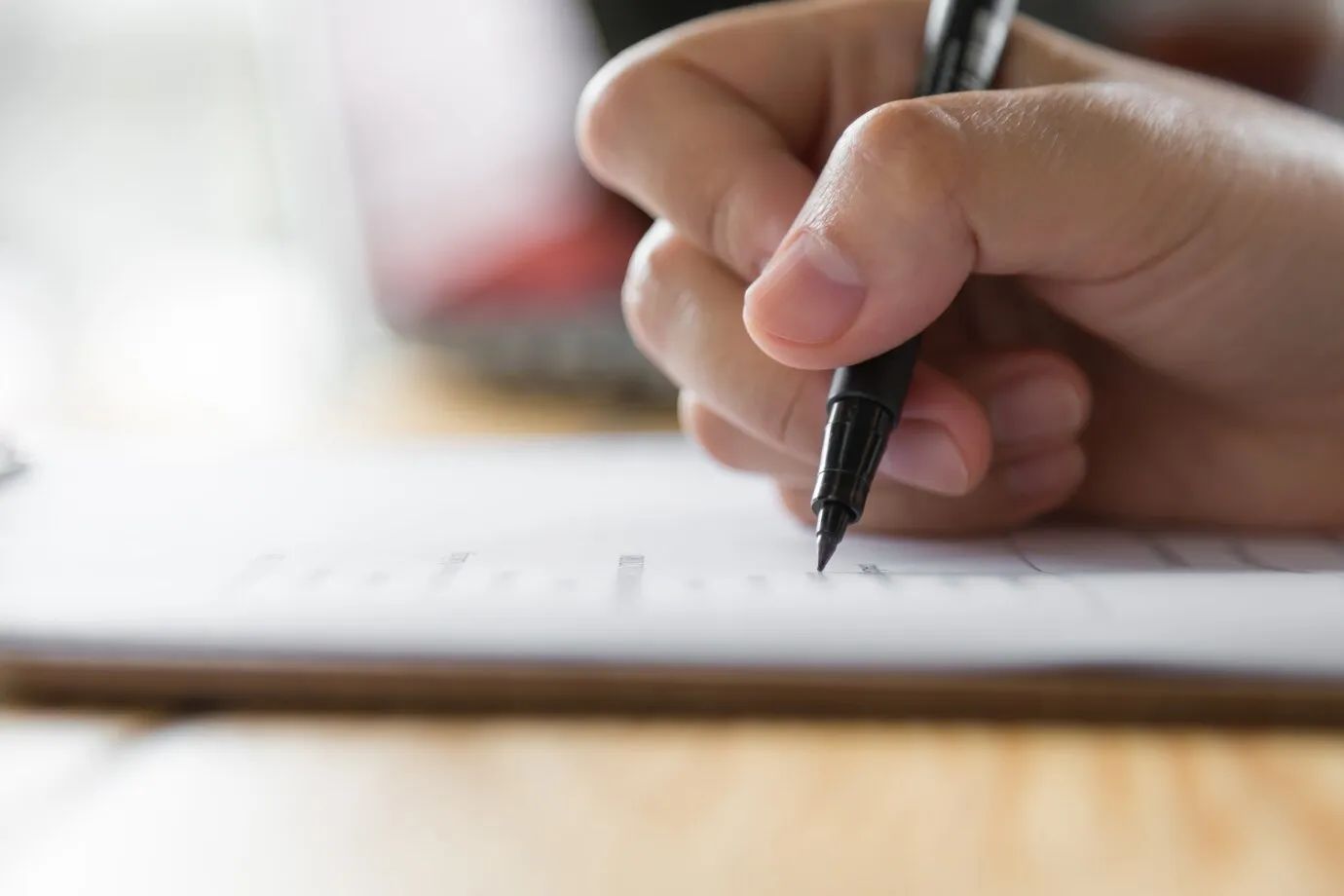 concurso CAESB Pessoa preenchendo uma ficha de inscrição, representando o processo de participação no concurso.