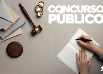 Pessoa escrevendo em caderno ao lado de martelo da justiça, simbolizando estudo para concurso público do TJ SP.