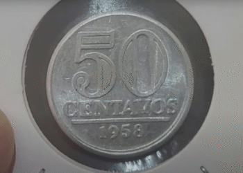 Moeda de 50 centavos de 1958 sendo examinada por possível erro de cunhagem