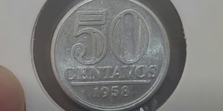 Moeda de 50 centavos de 1958 sendo examinada por possível erro de cunhagem