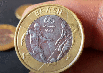 Moeda de 1 real das Olimpíadas com erro de cunhagem, mostrando jogadores de futebol.