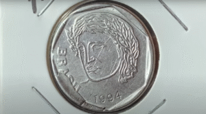 Moeda de 25 centavos de 1994 com defeito no cunho reverso Reverso da moeda de 25 centavos de 1994 mostrando o rosto com defeito de cunho quebrado