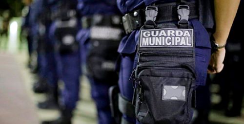 Uniforme da Guarda Municipal em formação, destacando oportunidades no serviço público.