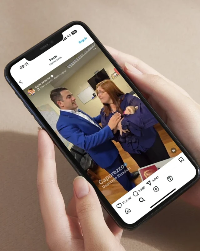 Projeto de Lei para bebê reborn Homem de terno azul cumprimentando mulher com bebê enrolado em manta azul, em ambiente de escritório.