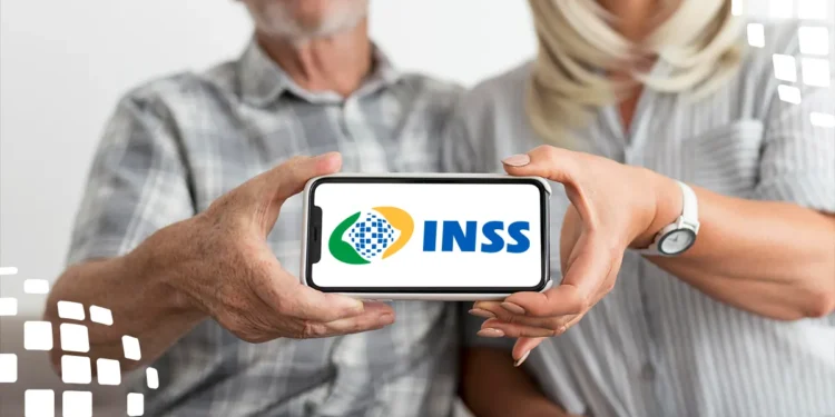 Casal de idosos segurando celular com logo do INSS na tela.