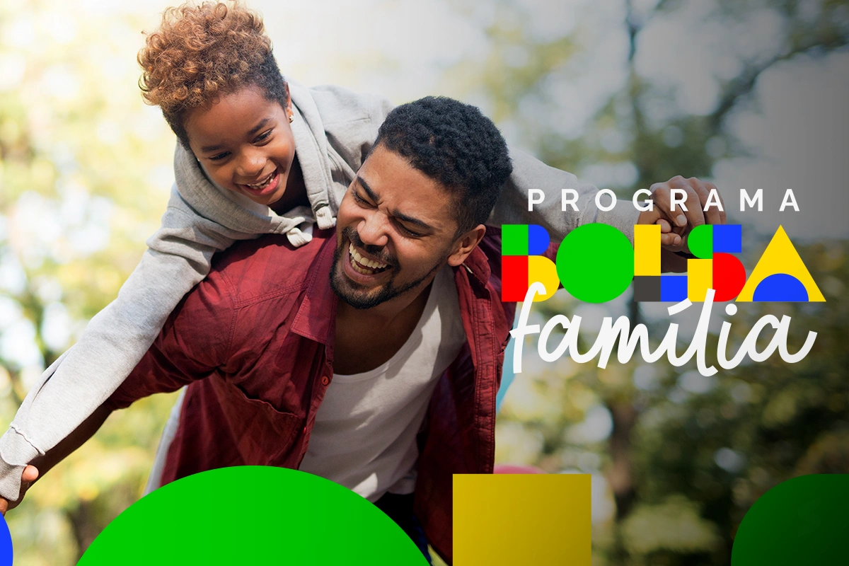 bolsa família Homem carregando criança alegremente em um ambiente ao ar livre, representando alegria familiar.