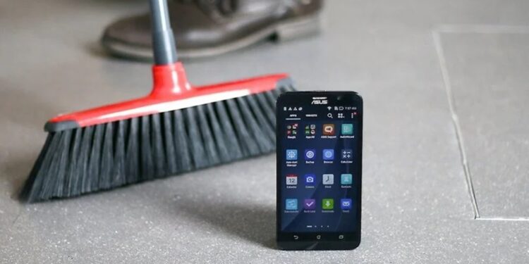 Imagem de um celular ASUS ao lado de uma vassoura, sugerindo a ideia de limpeza digital para celulares.