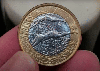 Moeda comemorativa de R$1 da Natação dos Jogos Rio 2016 com possível defeito de cunhagem no joelho do atleta.