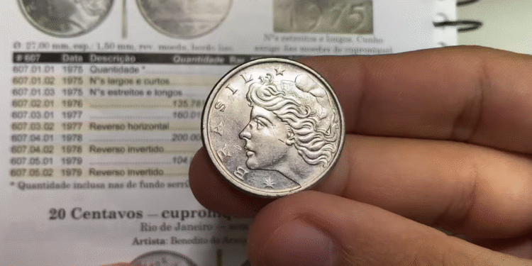 Moeda antiga de 50 centavos do Brasil sendo segurada entre os dedos, mostrando o lado com a efígie da República.
