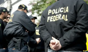 t: policiais federais durante operação vestidos com uniformes da PF em área externa