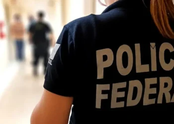 Agente da Polícia Federal em ação nos corredores de uma unidade.
