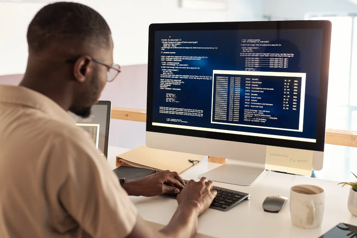 Programador trabalhando com código em um ambiente de escritório moderno.
