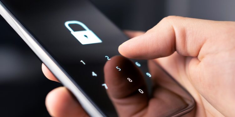 Segurança Digital: Pessoa segurando celular com tela bloqueada mostrando ícone de cadeado e teclado numérico para senha